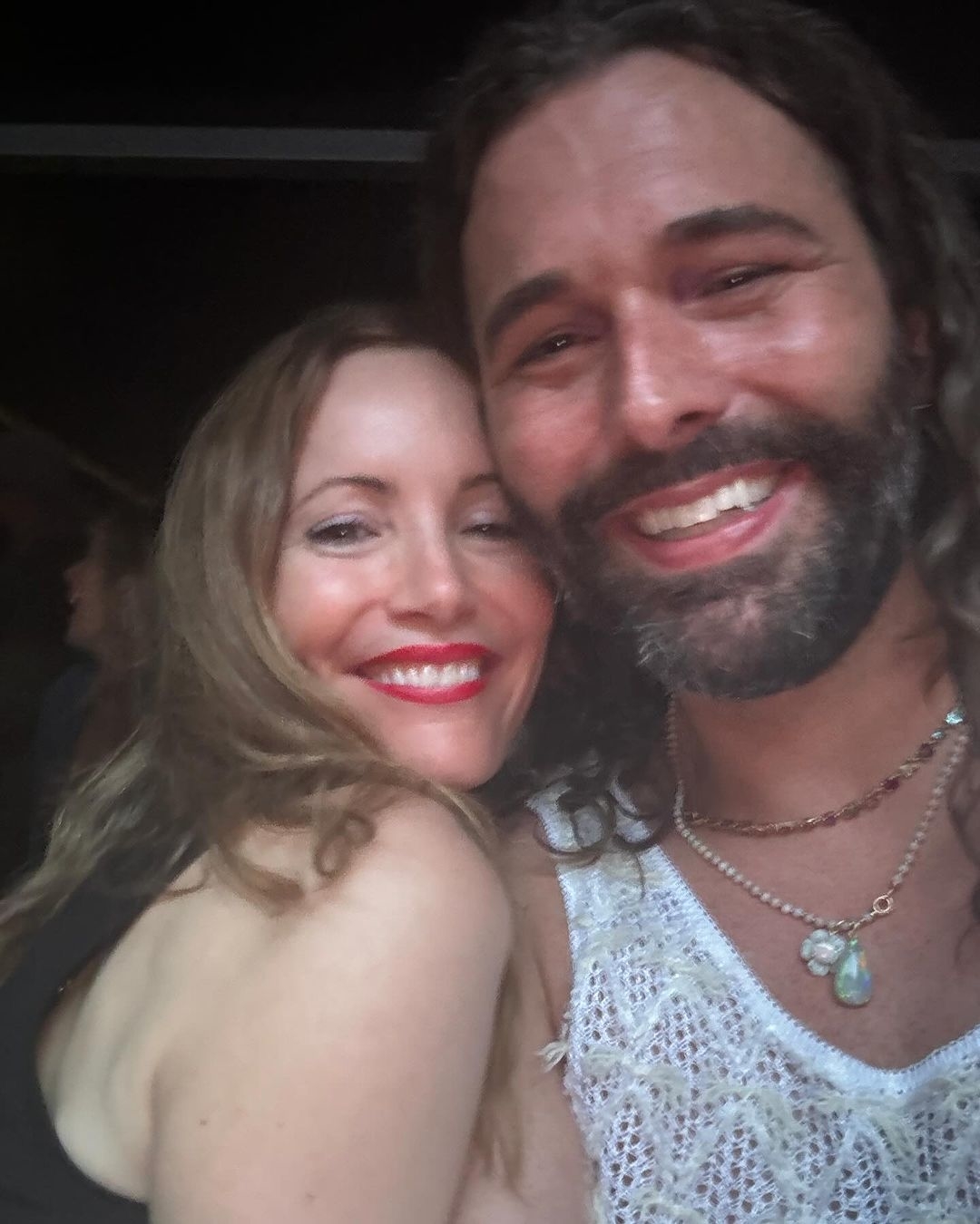 Leslie Mann and Jonathan Van Ness smiling closely together in a casual setting