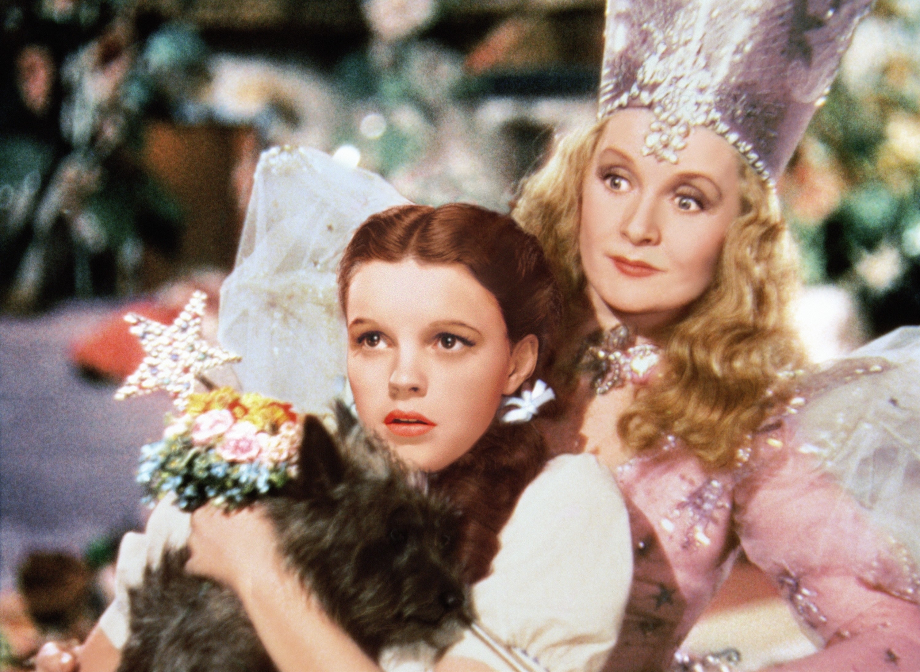 Dorothy (Judy Garland) holding Toto with Glinda the Good Witch (Billie Burke) in a scene from "The Wizard of Oz"
