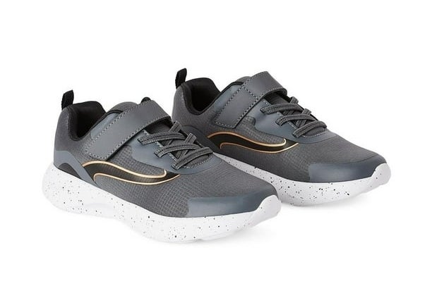 A pair of gray athletic shoes with white speckled soles and black laces is displayed. The design includes curved gold accents on the sides