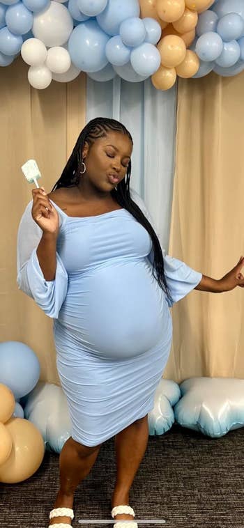 A pregnant reviewer wearing the dress