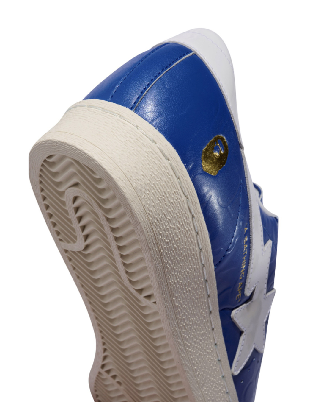Close-up of a blue and white sneaker with a textured sole, showcasing the sneaker&#x27;s design details