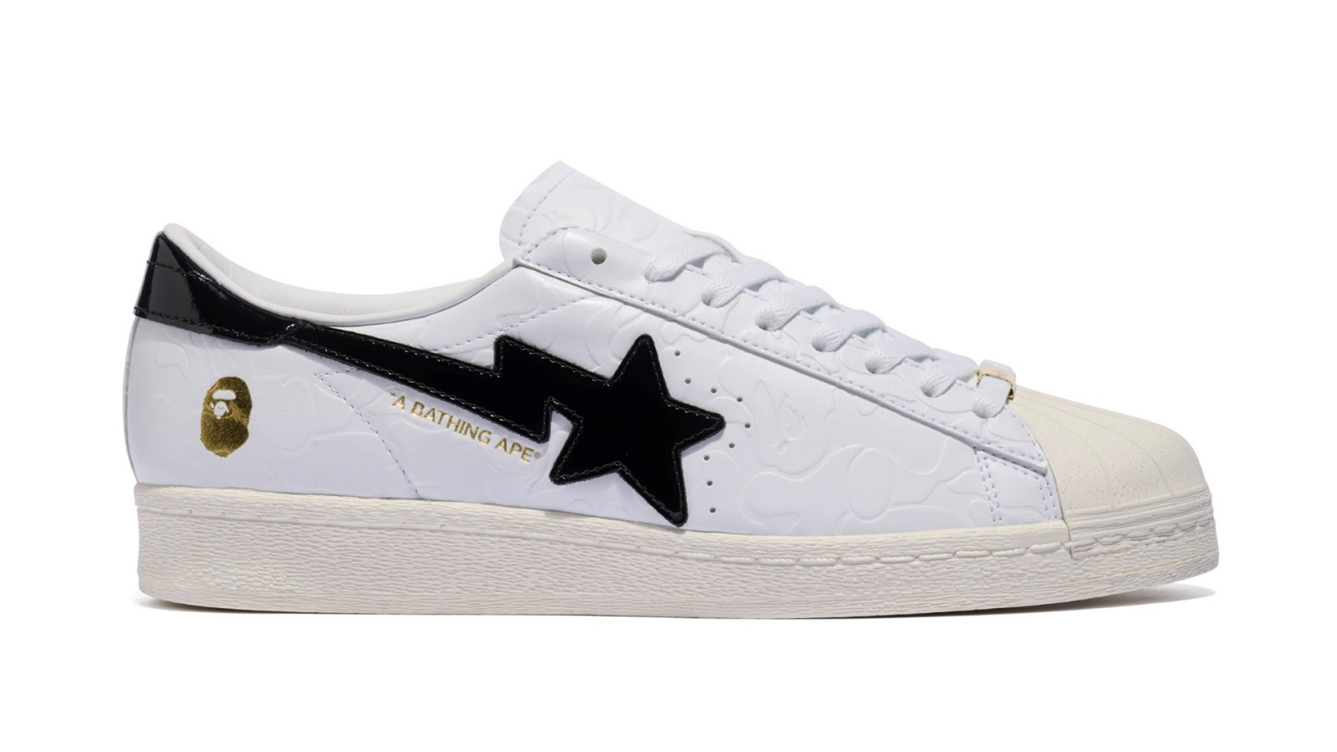 Side view of a white BAPE x adidas Superstar sneaker, featuring a black star logo and gold branding detail near the heel