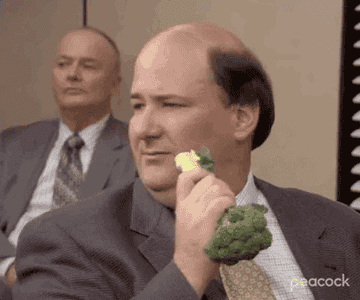 Kevin from &quot;The Office&quot; holds a broccoli floret to his face and takes a bite.