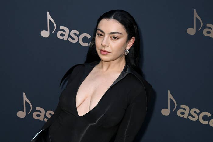 Charli XCX in a plunging neckline black dress at a music industry event
