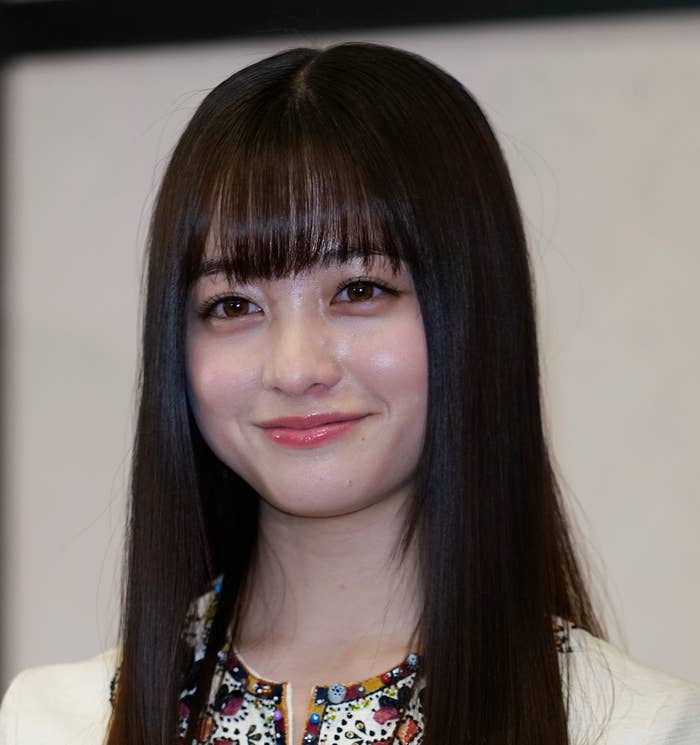 橋本環奈がトロフィーを持って微笑む姿。刺繍の入った衣装を着用。