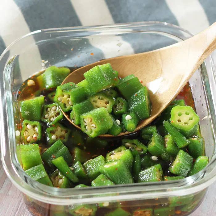 木のスプーンでかき混ぜられたガラス容器に入った刻みオクラ。