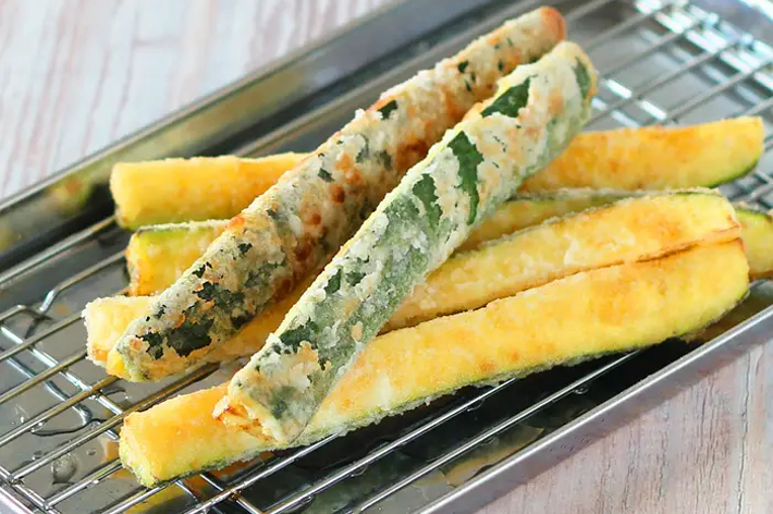 金属製のトレイに盛り付けられている天ぷらのズッキーニとさつまいも。