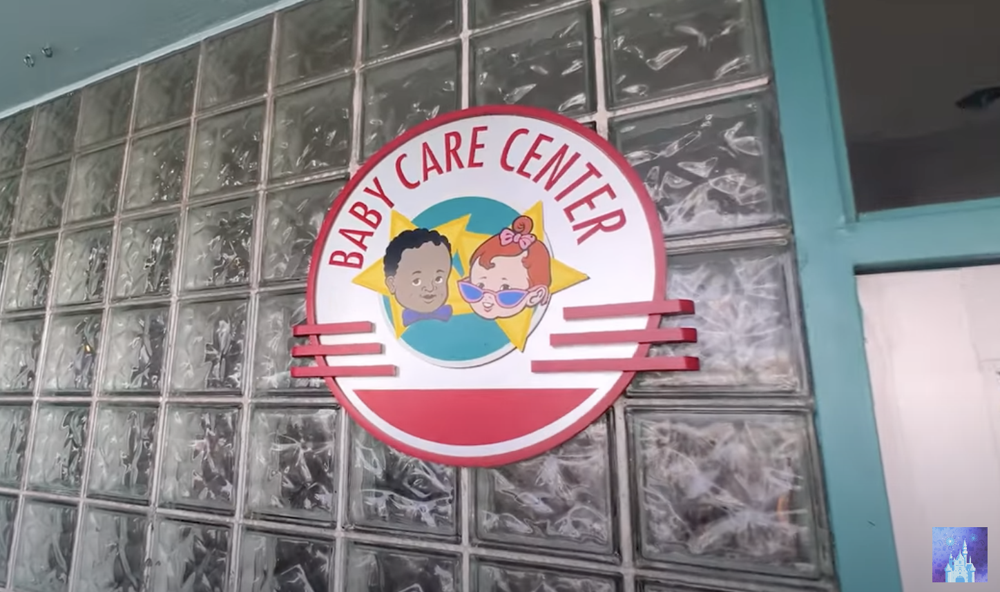 Sign for Baby Care Center with cartoon illustrations of a baby boy and baby girl wearing glasses