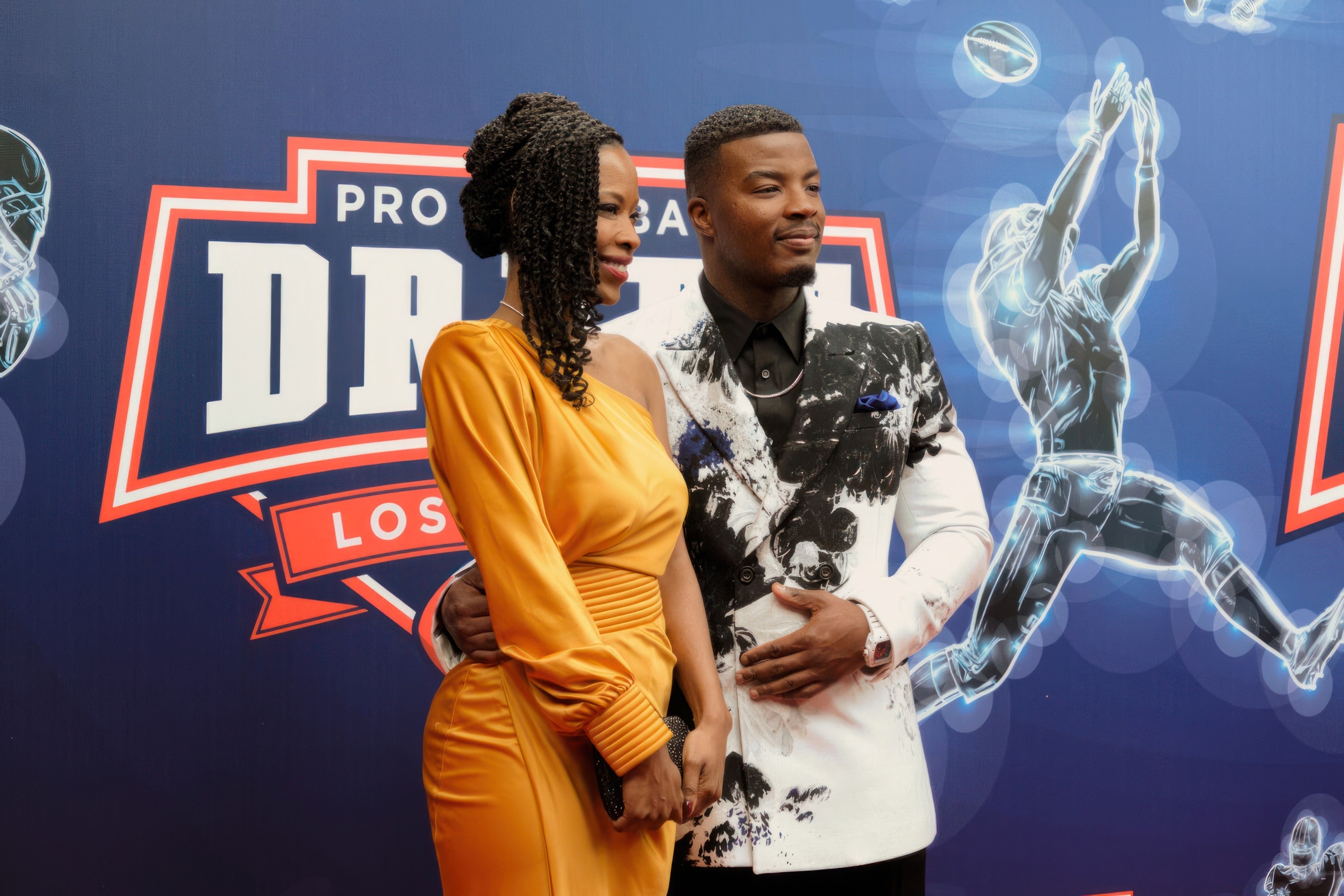 Daniel Ezra and a woman posing on the red carpet