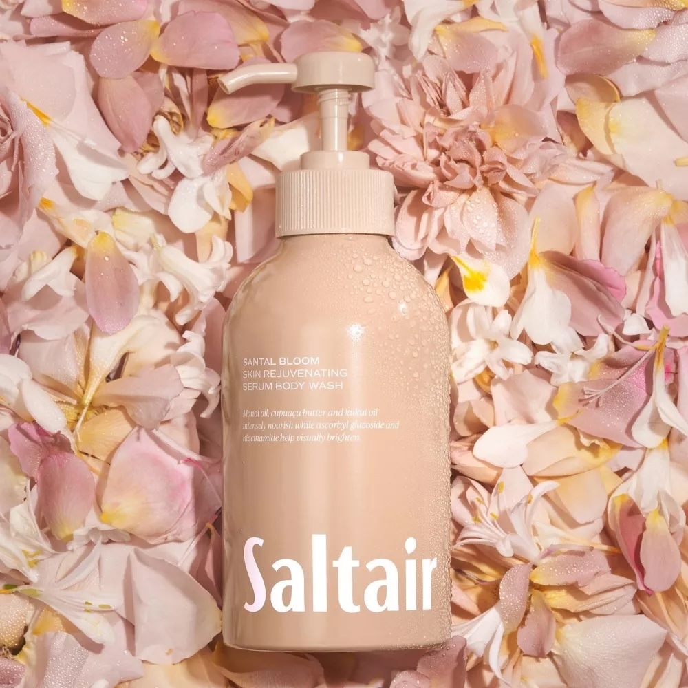 Saltair's Santal Bloom Skin Rejuvenating Serum Body Wash bottle surrounded by flower petals