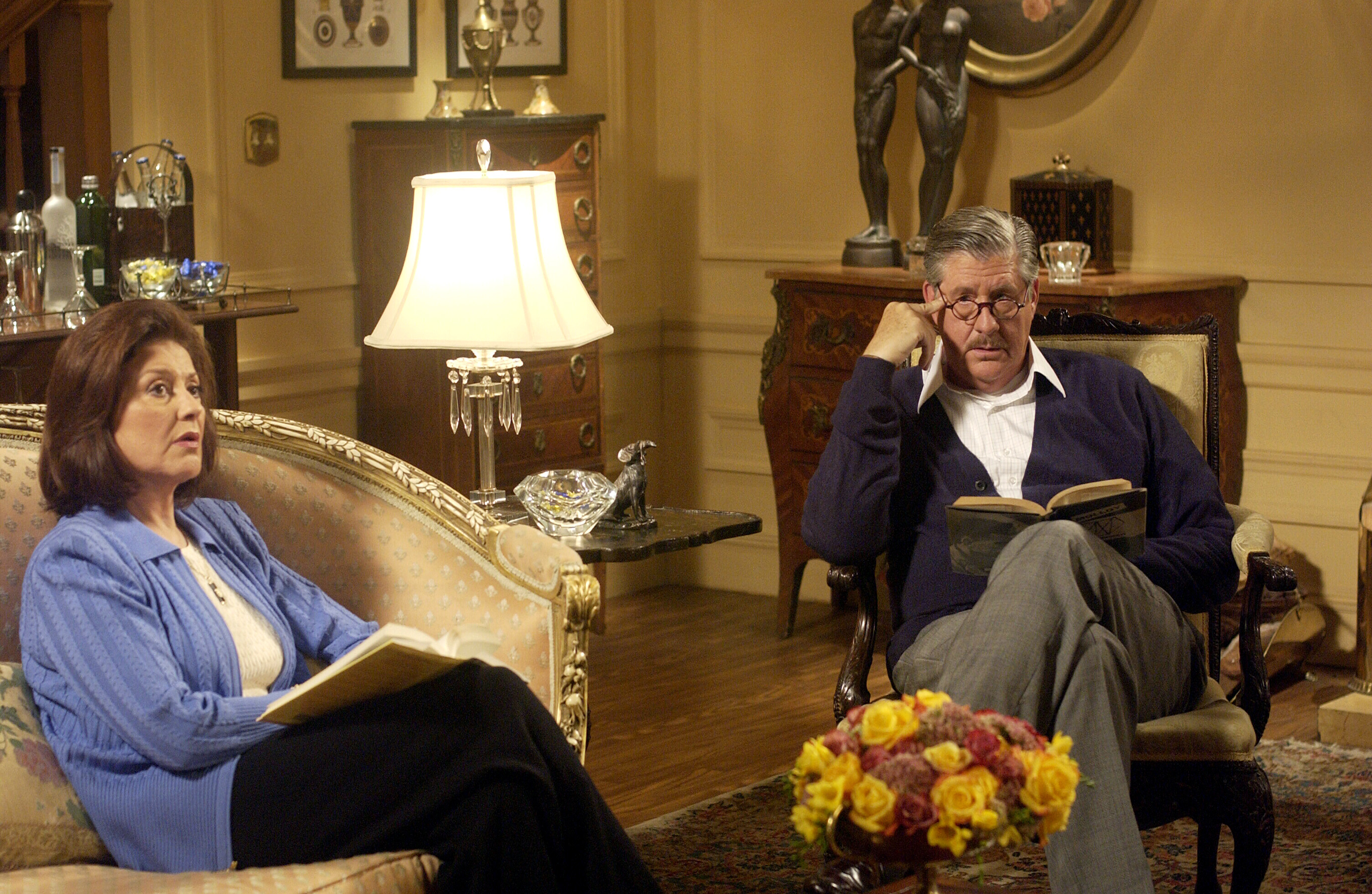 Emily and Richard Gimore sitting in an ornate living room, reading books