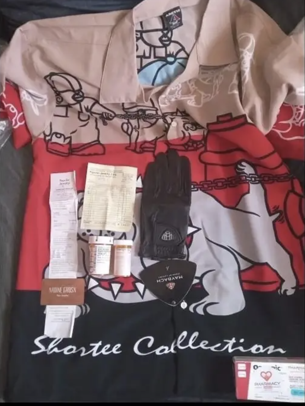 Items from the &quot;Shortee Collection&quot; including a patterned shirt, black glove, two prescription bottles, a receipt, a note, and a product tag
