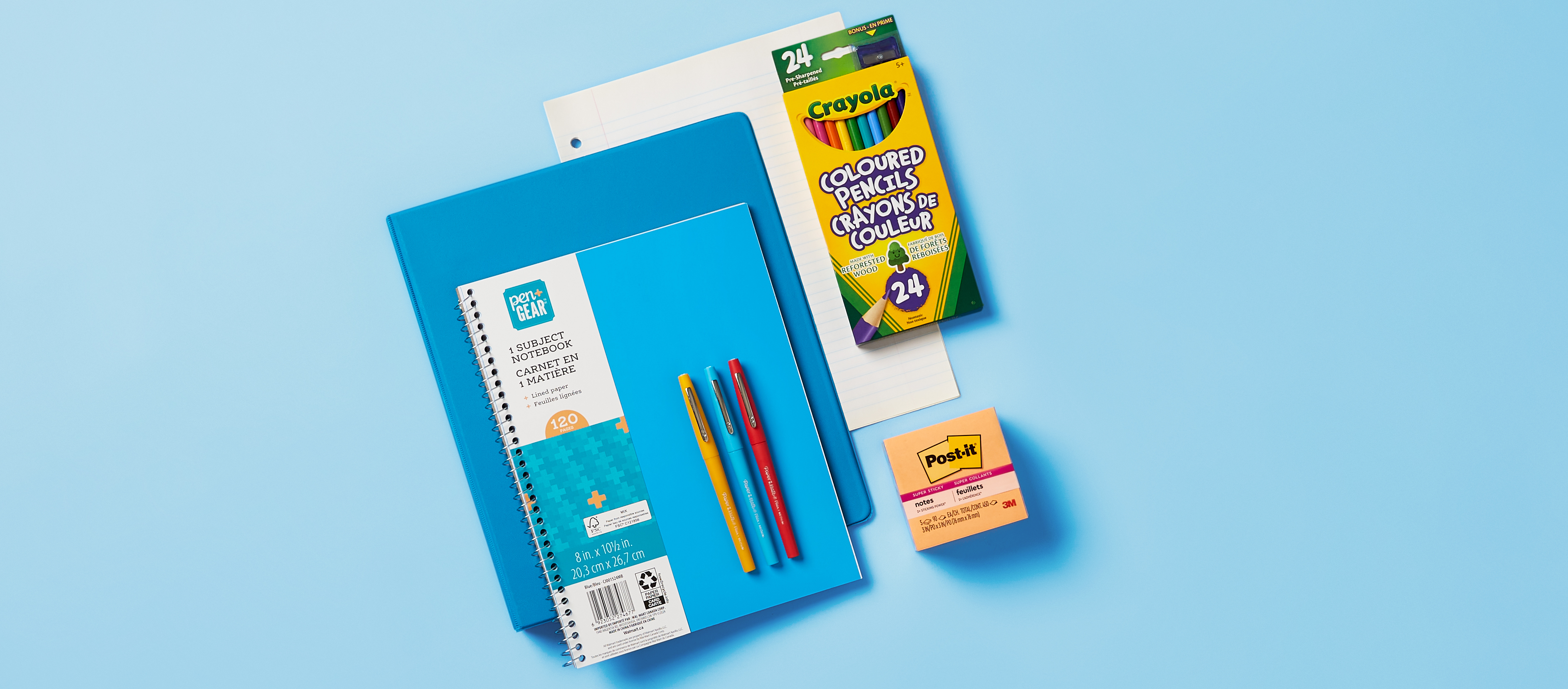 A set of school supplies on a light blue background, including a notebook, folders, colored pencils, pens, a sticky note pad, and loose-leaf paper