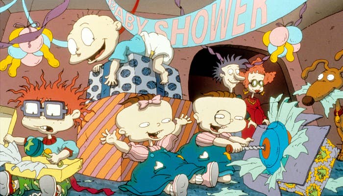 Chuckie, Tommy, Phil, Lil, Didi, Grandpa Lou, and Spike the dog are surrounded by gifts and decorations in &quot;The Rugrats Movie&quot;