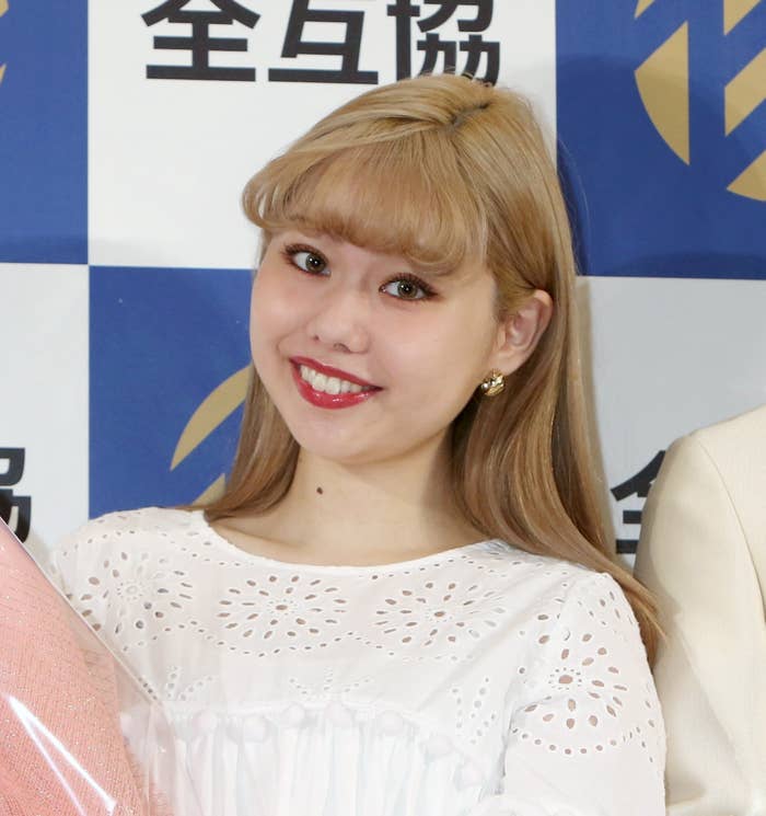 全互協イベントで白いドレスを着て微笑む女性。