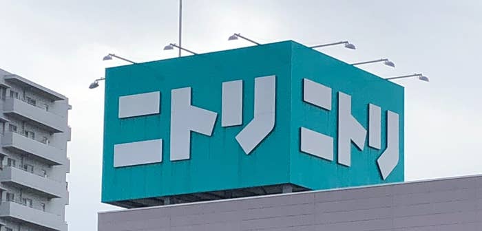 ニトリの看板が見える建物の外観。背景には高層マンションが写っています。