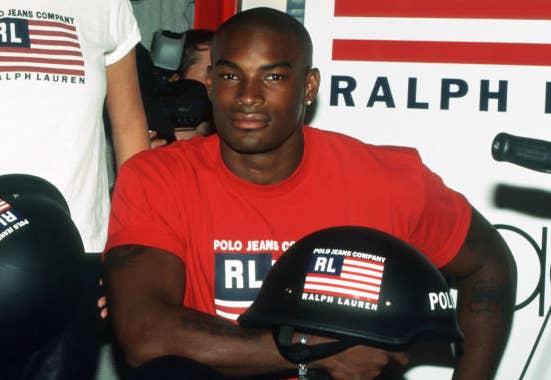Kim Kardashian and a man, both wearing Polo Ralph Lauren shirts and holding Polo Ralph Lauren branded helmets, posing in a store