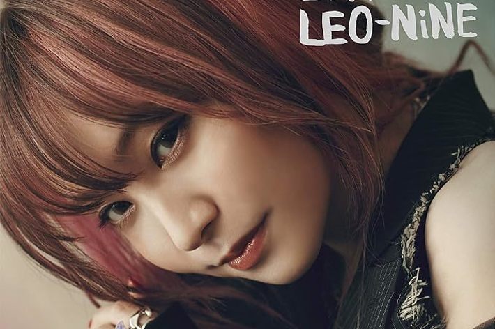 LiSAが『LEO-NiNE』のアルバムカバーでカメラを見つめる。