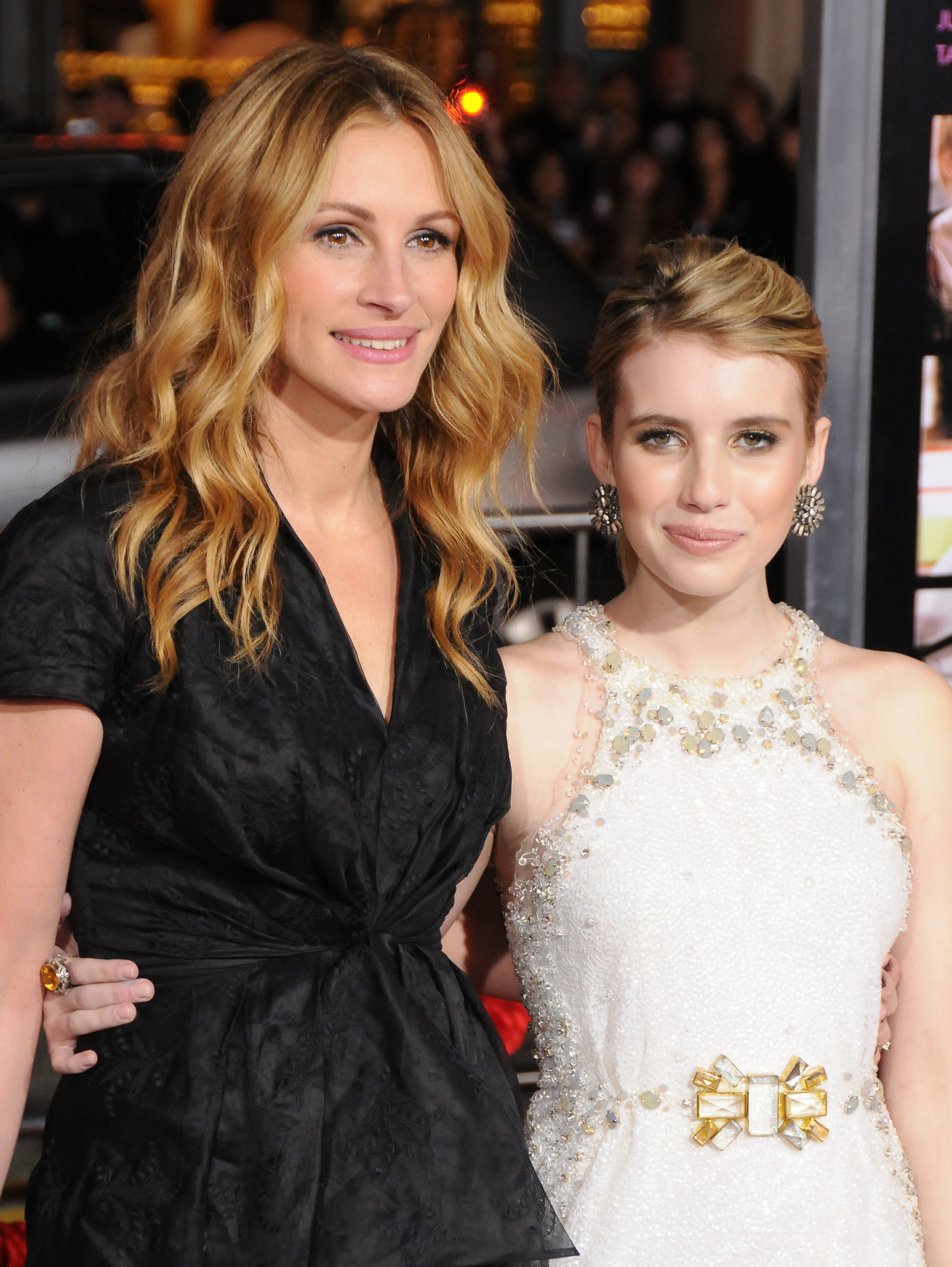 Julia Roberts and Emma Roberts pose together on the red carpet; Julia is wearing a dark dress, and Emma is in a halter dress with jeweled embellishments