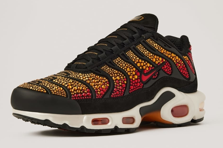Nike Women's Air Max Plus sneaker adorned with Swarovski crystals, displayed against a plain background. Text reads "Women's Air Max Plus with Swarovski Crystals," noting the collaboration