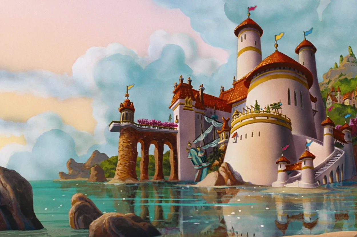 Animated castle with red roofs, flying banners, and surrounded by water and mountains. The scene is from "The Little Mermaid."