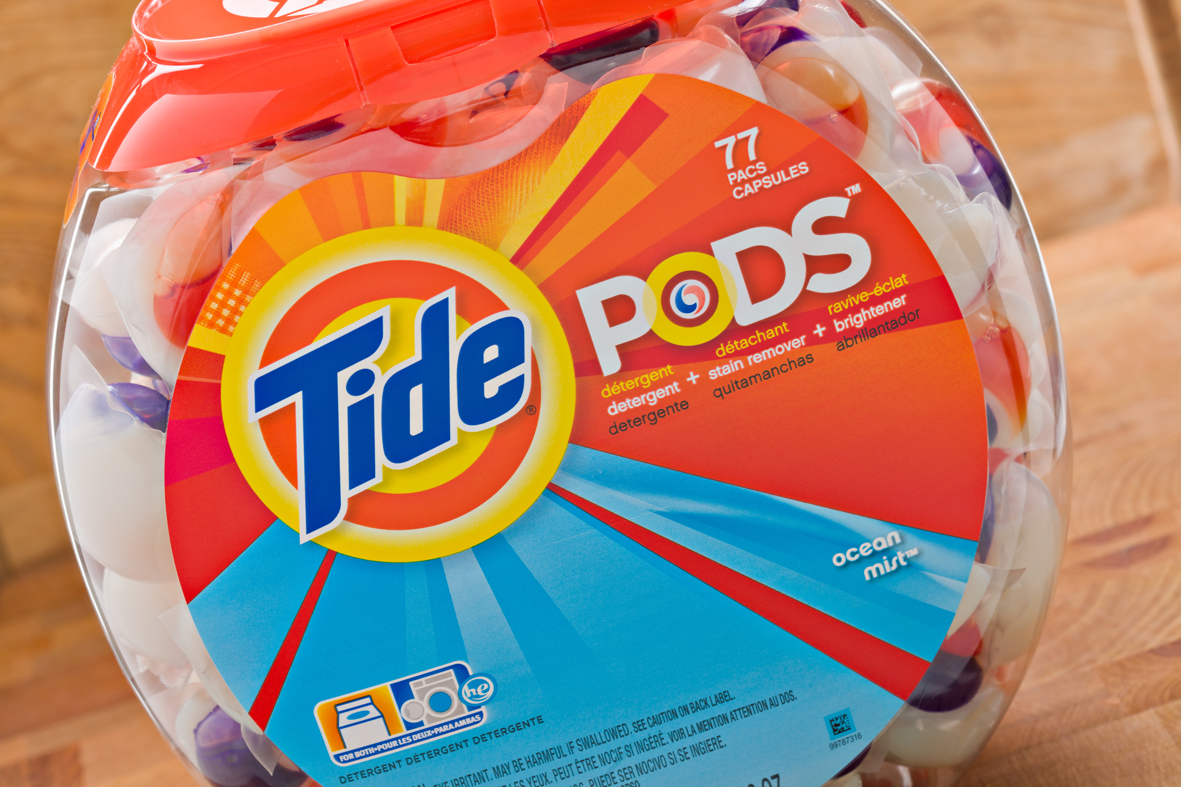 Tide Pods container labeled "77 pacs" with a design indicating detergent, stain remover, and color protector benefits