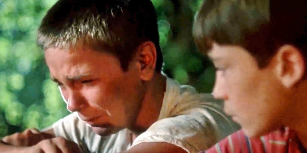 Two boys, one upset and crying while the other watches sympathetically