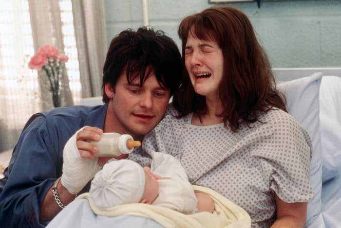 Steve Zahn and Drew Barrymore in "Riding in Cars with Boys." Drew is sitting in a hospital bed holding a baby and crying while Steve holds a bottle of milk