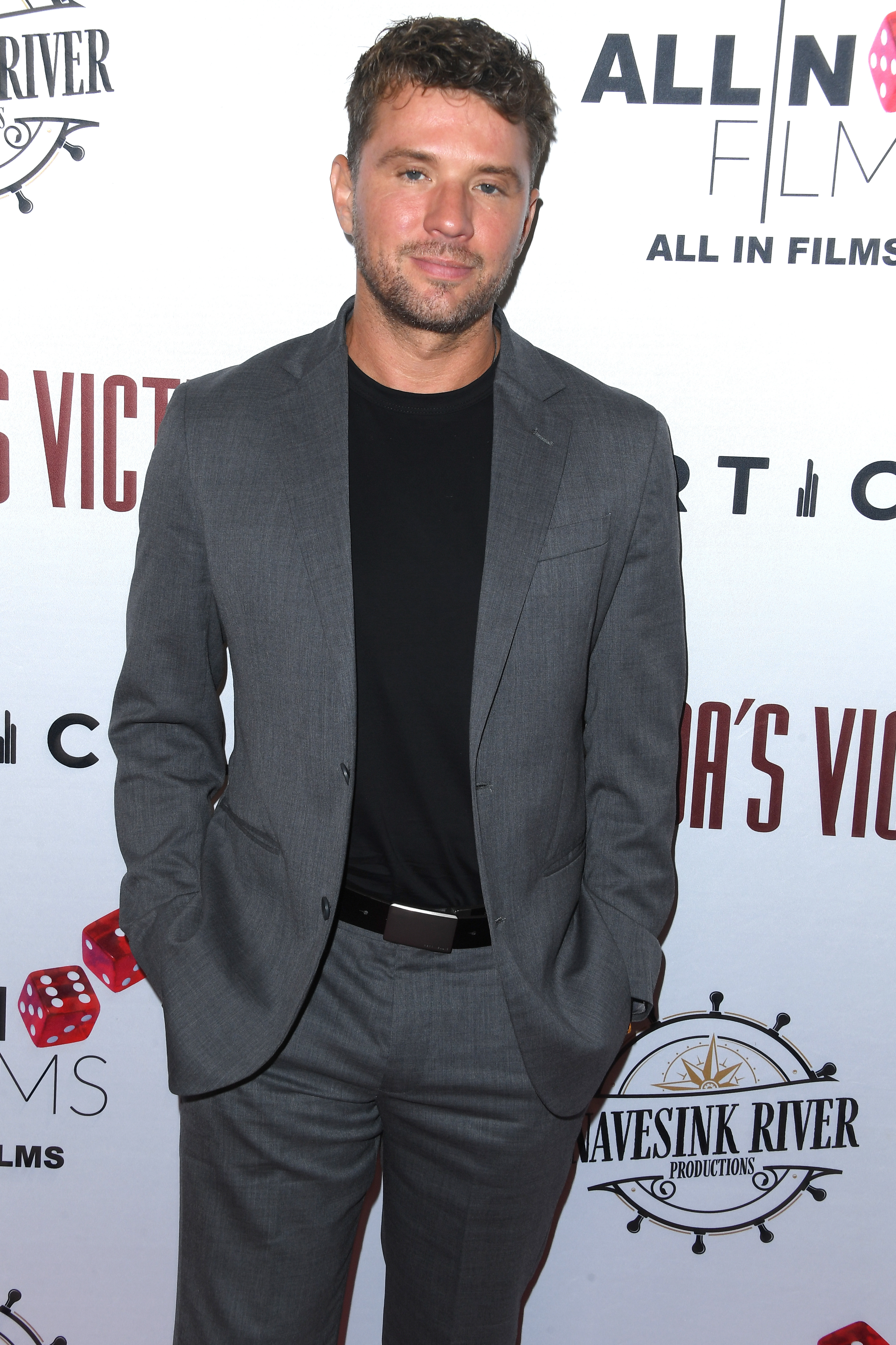 Ryan Phillippe in a tailored gray suit with a black shirt, at a red carpet event for &quot;All N Films.&quot;
