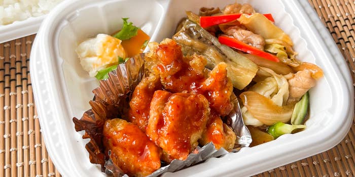 弁当に閉じられた鶏の唐揚げ、焼き野菜、ピクルス、そしてご飯。