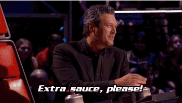 Blake Shelton, seated at a judge's panel, speaks animatedly with the caption &quot;Extra sauce, please!&quot; in the foreground