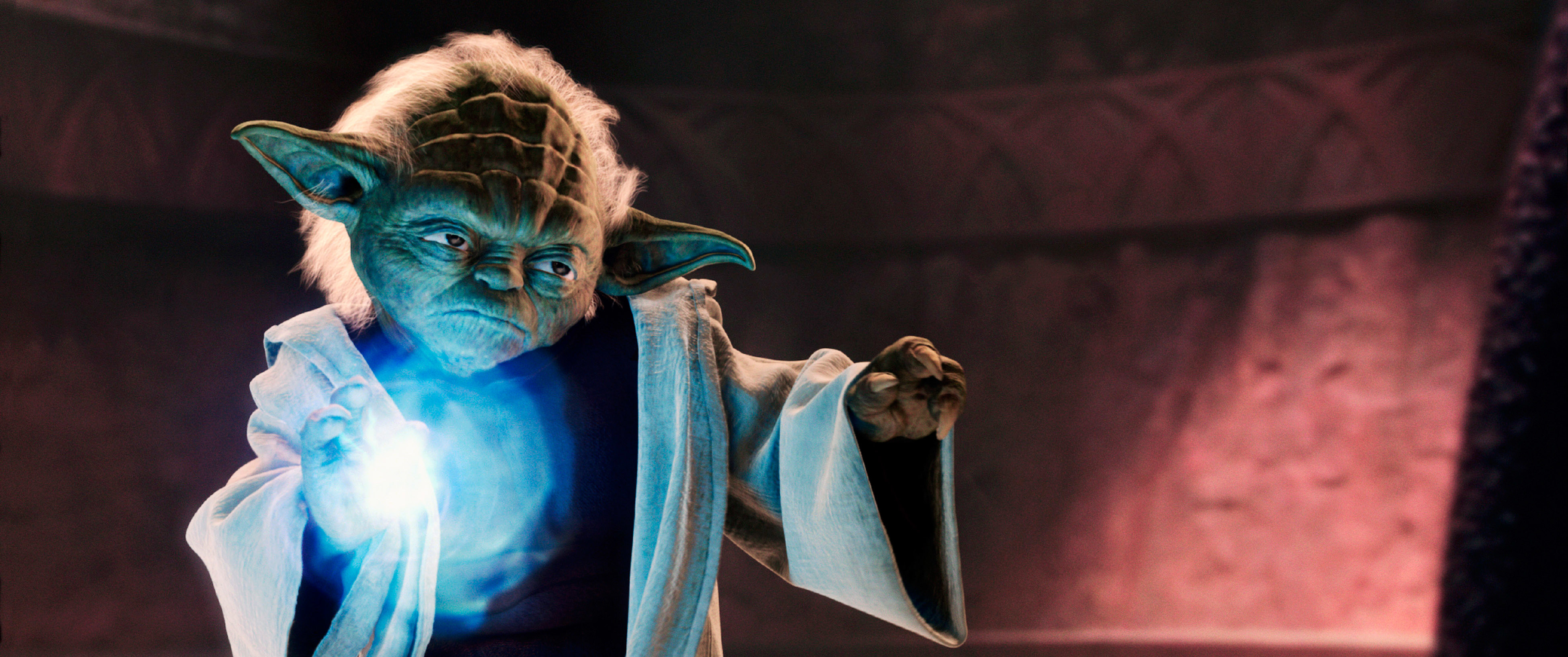 Yoda from Star Wars, wearing a white robe, uses the Force to levitate a glowing blue orb in a dimly lit setting