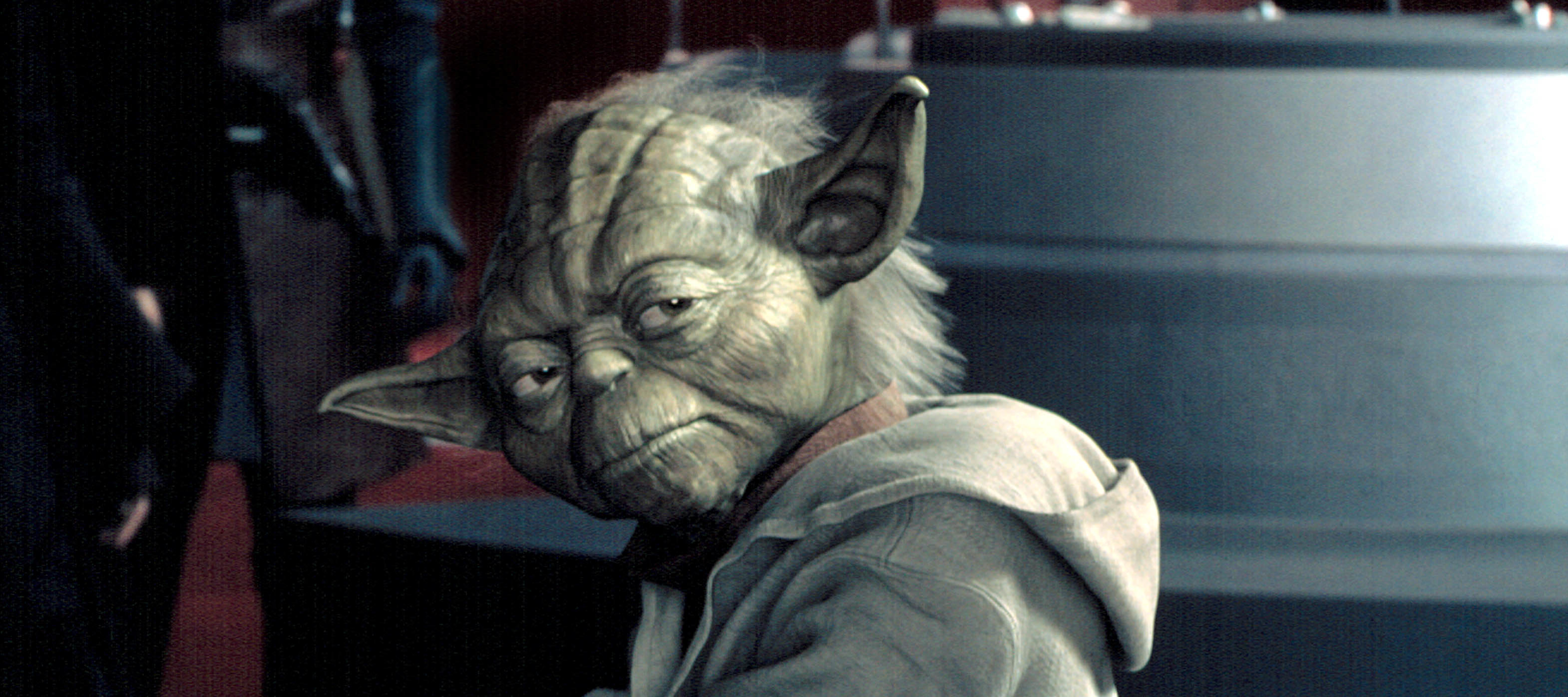 Yoda sitting in a room, wearing his traditional Jedi robes, from the "Star Wars" movies