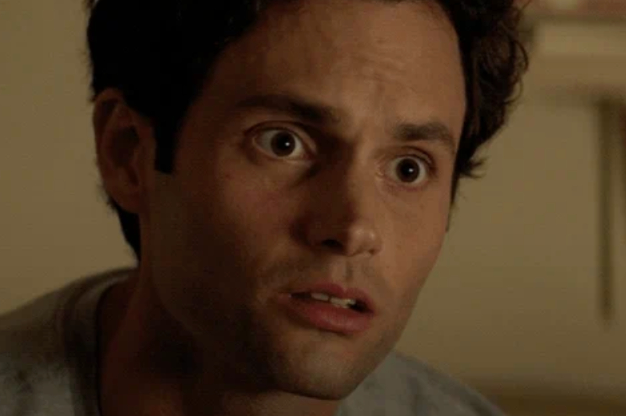 A man with an anxious facial expression looks concerned or startled. His hair is tousled, and he wears a casual shirt