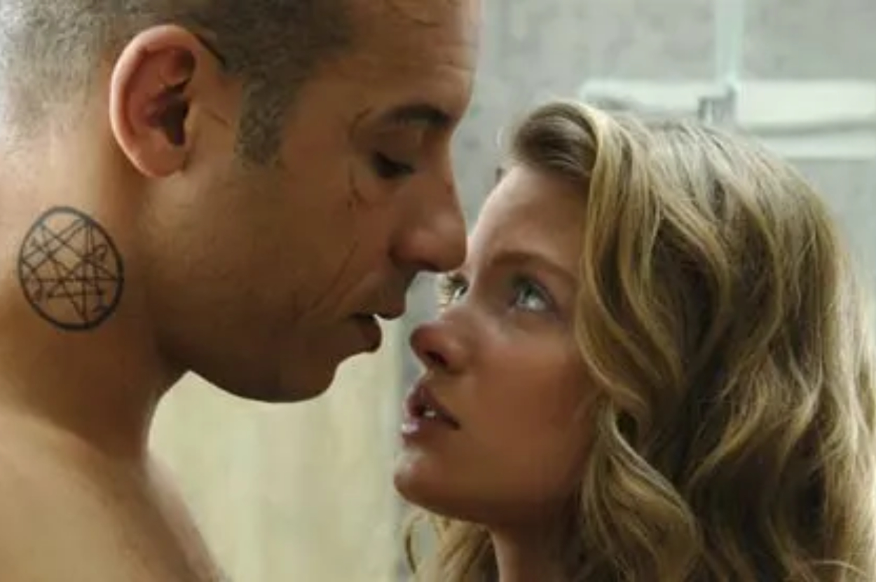 Vin Diesel and Nathalie Kelley are in a close stare, with Vin sportings a shaved head and neck tattoo, while Nathalie has wavy hair