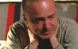 A man is crying while holding his hands to his neck