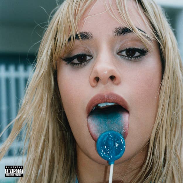 Close-up of singer Camila Cabello licking a blue lollipop, with an explicit content warning in the bottom-left corner