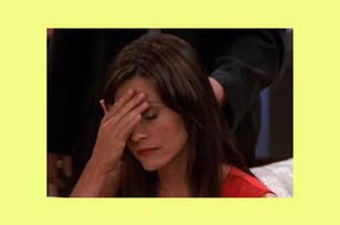 Courteney Cox from Friends covers her face with her hand, appearing distressed