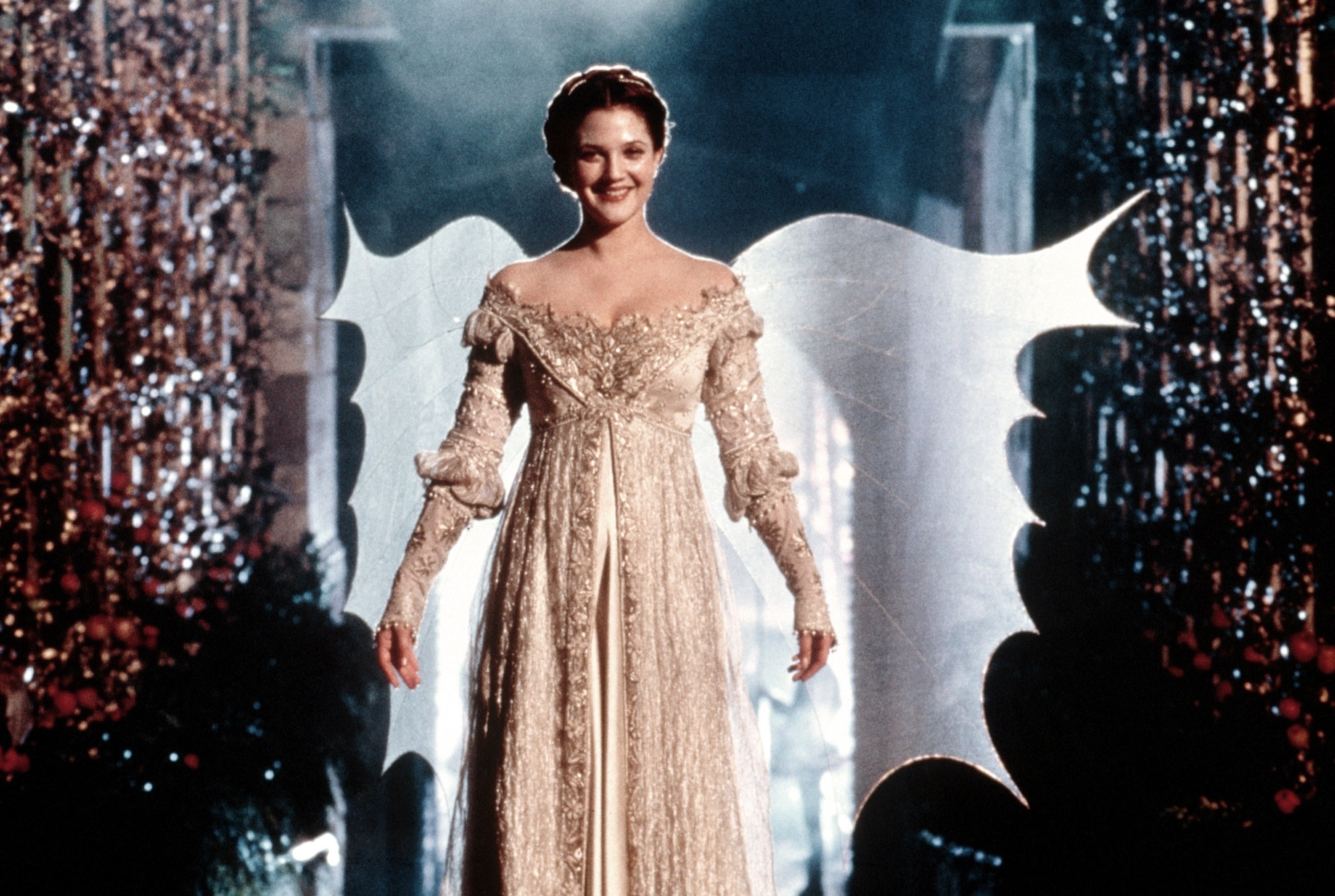 Drew Barrymore in a fantasy-inspired lace gown with wing-like backdrop on a film set