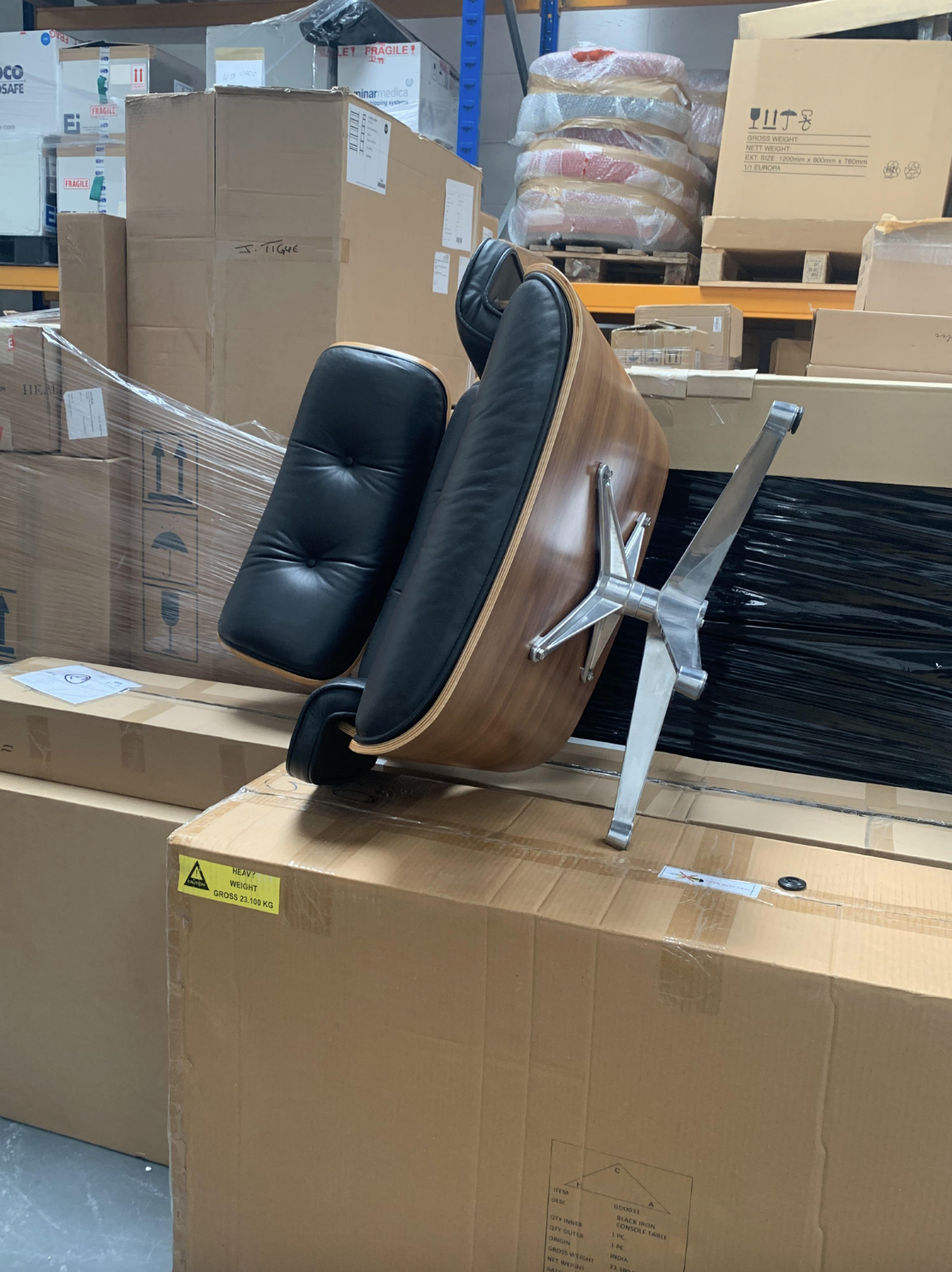 An overturned office chair on its side amidst cardboard boxes in a warehouse setting