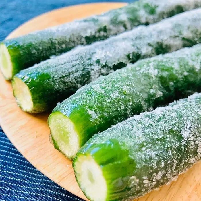 木製の皿に載った凍ったキュウリが4本あります。
