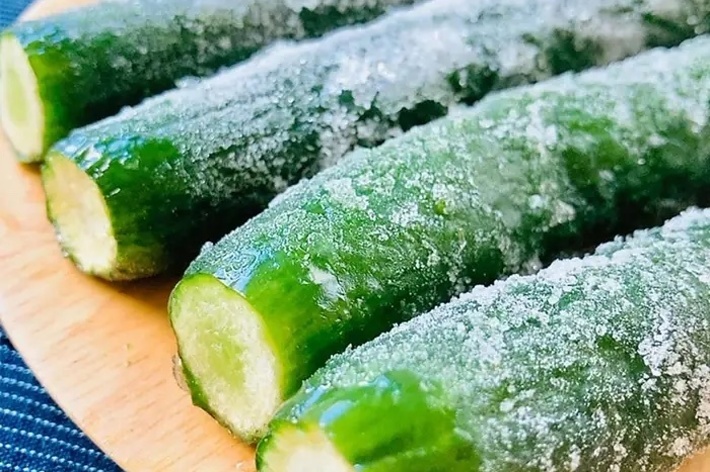 冷凍された4本のキュウリが木の皿の上に置かれています。