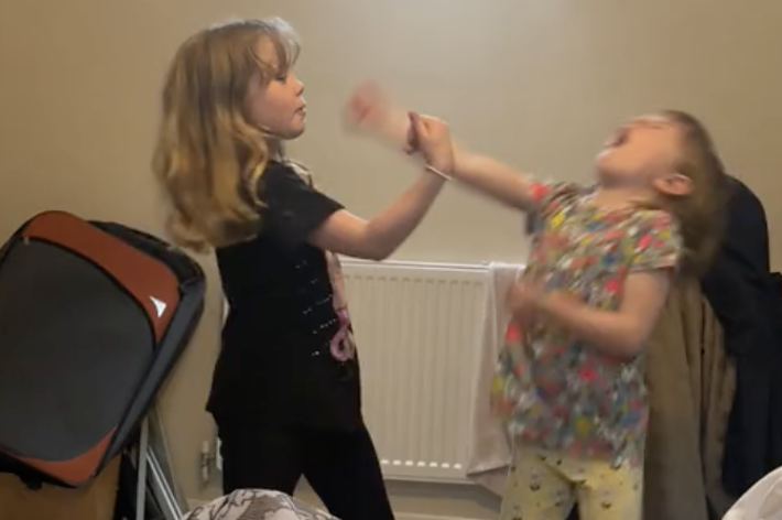 2人の幼児が室内でじゃれ合っています。インテリアが背景にありますが、特定の人物としては不明です。