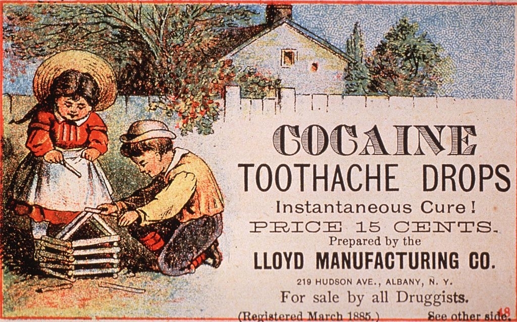 Two children play with a toy house outside; an old for cocaine toothache drops is displayed, claiming it as an "Instantaneous Cure" for 15 cents