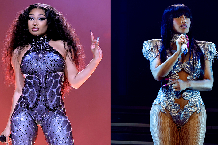 Megan Thee Stallion and Nicki Minaj performing on stage in stylish, form-fitting outfits during a music event. Megan wears a patterned bodysuit, and Cardi wears a silver, embellished costume with tassels
