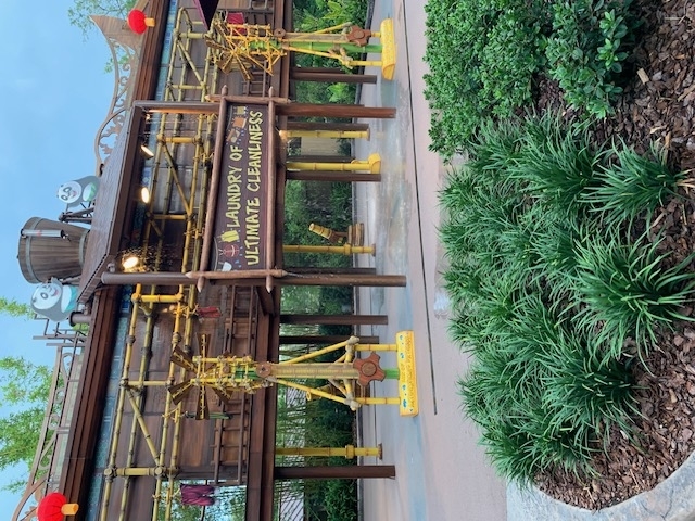 Mr. Ping's Noodle Kaboodle restaurant entrance with decorative sign featuring a bird mascot holding noodles above and wooden façade in the background