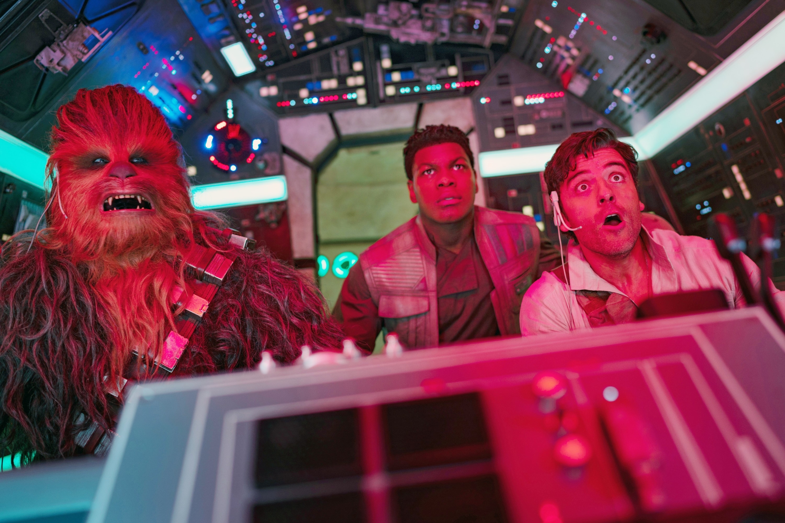 Chewbacca, John Boyega, and Oscar Isaac appear in a spaceship cockpit scene from a movie