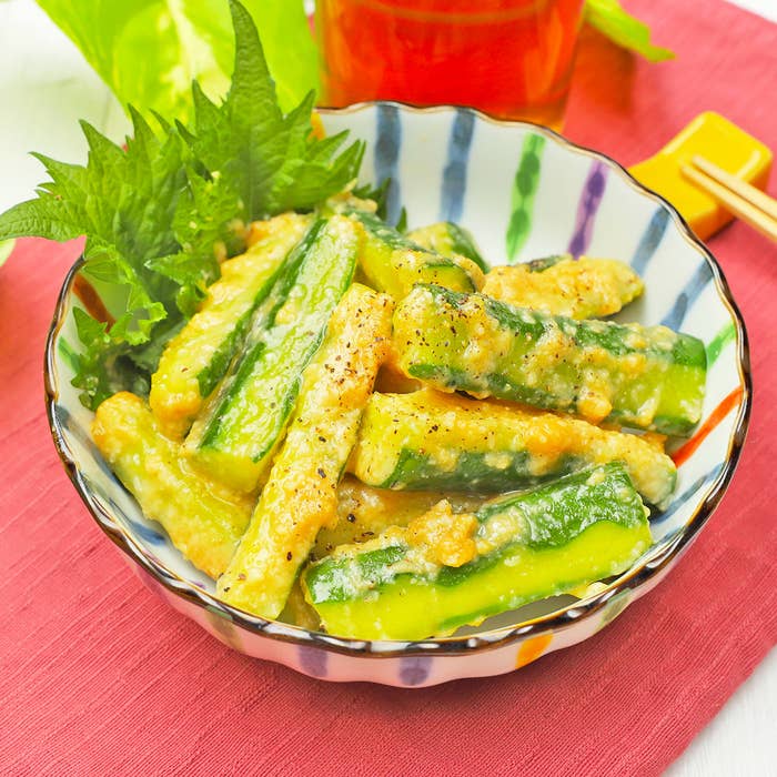 緑の野菜の和風サラダが盛り付けられた美しいボウルがテーブルに置かれている。