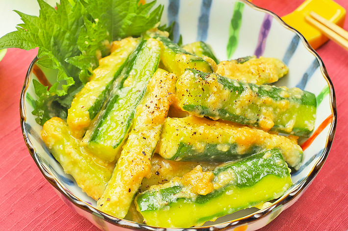 緑の野菜の和風サラダが盛り付けられた美しいボウルがテーブルに置かれている。