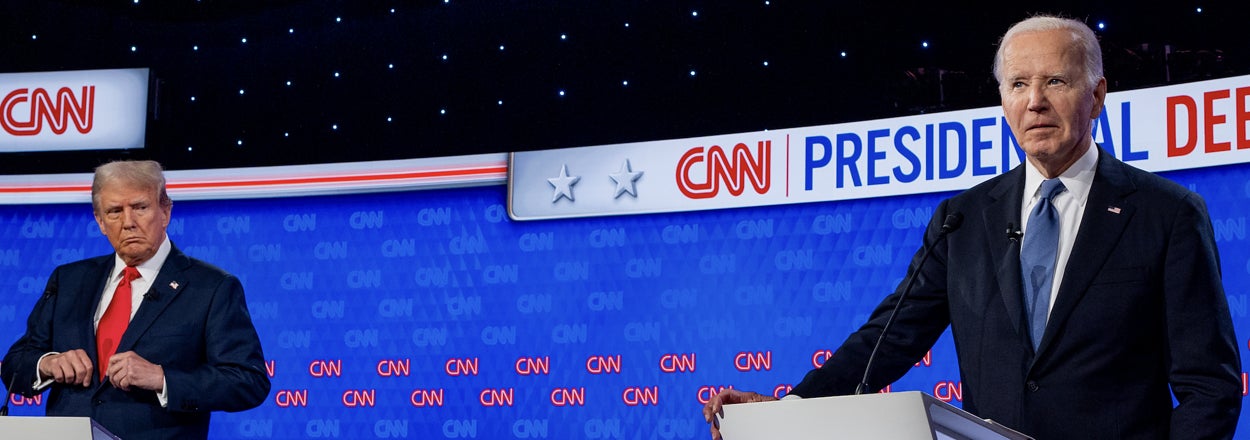 Donald Trump and Joe Biden stand behind podiums on a CNN debate stage labeled "Presidential Debate" with CNN logos visible in the background